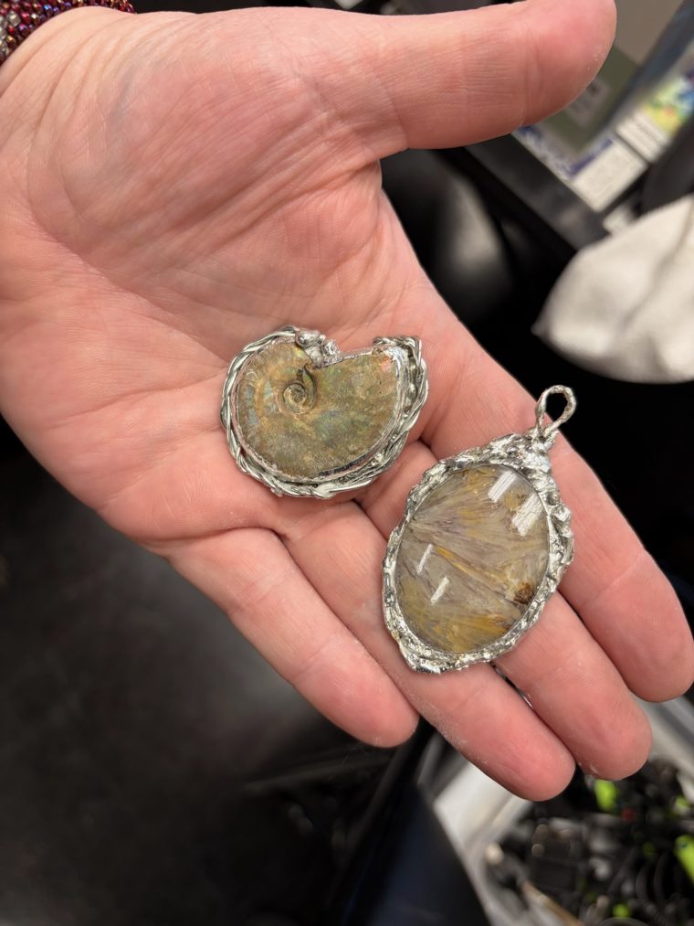 Ammonite fossil and rutilated quartz pendants made by a student at a beginner soldering class in Cleveland